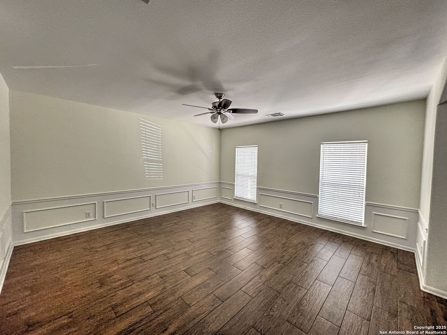 8711 Sandia Circle Helotes, TX 78023 - Photo 10 of 40 an empty room with wooden floor fan and windows