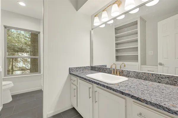 a bathroom with a granite countertop sink and a mirror