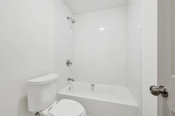 a white toilet sitting next to a bath tub