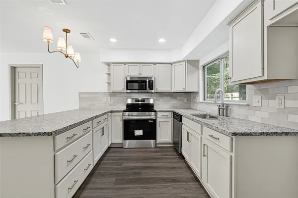 a kitchen with granite countertop white cabinets and white appliances