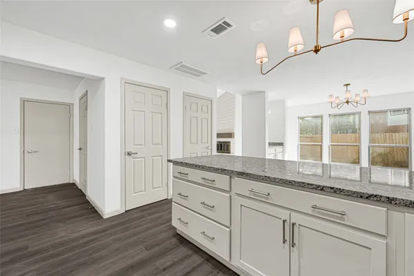 a bathroom with a granite countertop sink mirror and cabinets