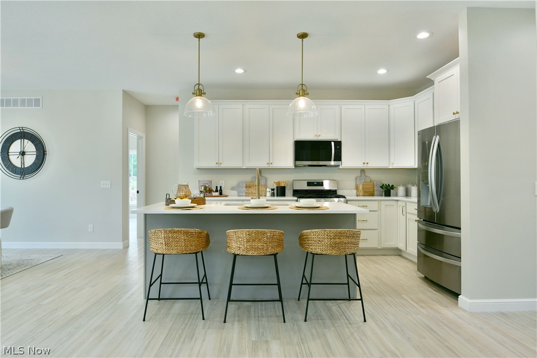 4780 State Rte 5 Cortland, OH 44410 - Photo 9 of 50 Kitchen featuring white cabinetry, stainless steel appliances, a center island with countertop seating, and recessed lighting