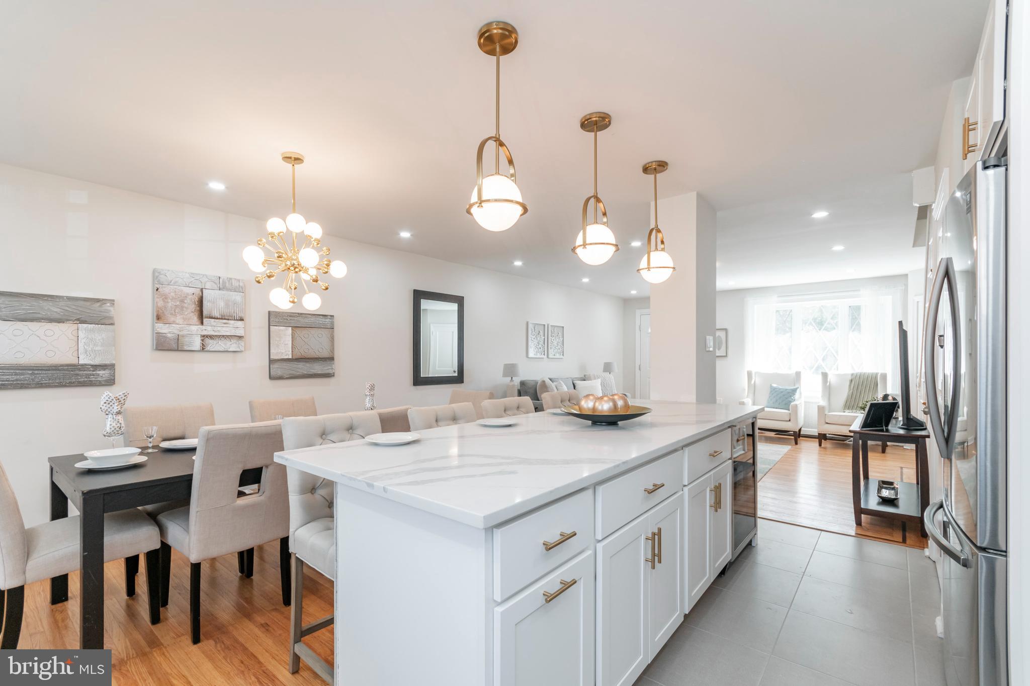a large kitchen with kitchen island white cabinets and chandelier