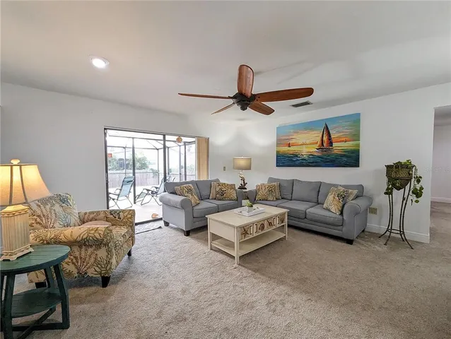 a living room with furniture ceiling fan and a window