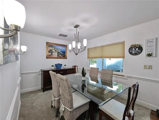 a view of a dining room with furniture a chandelier and wooden floor
