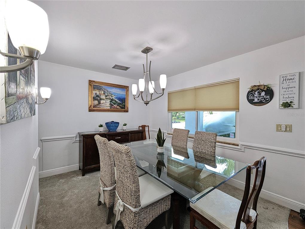 912 72nd Street Northwest Bradenton, FL 34209 - Photo 7 of 25 a view of a dining room with furniture a chandelier and wooden floor