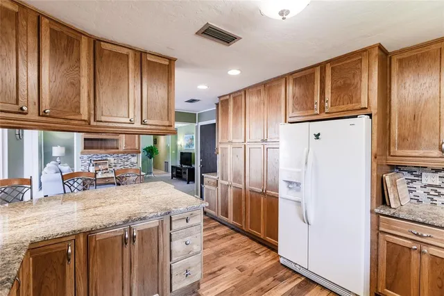 a kitchen with granite countertop a refrigerator and a sink