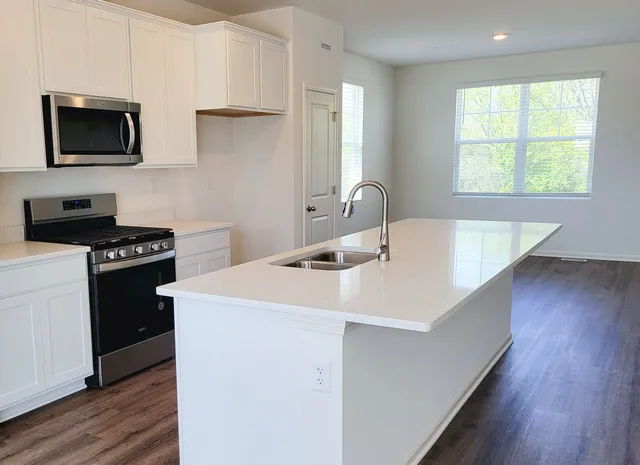 a kitchen with a sink a microwave and cabinets
