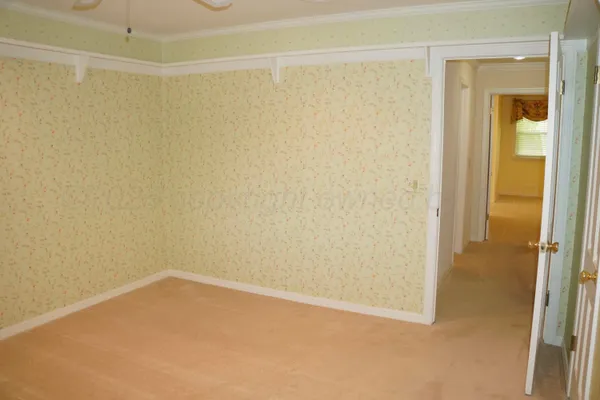 a view of a hallway with wooden floor and cabinet