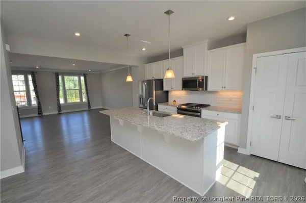 a view of an empty room with glass door and wooden floor