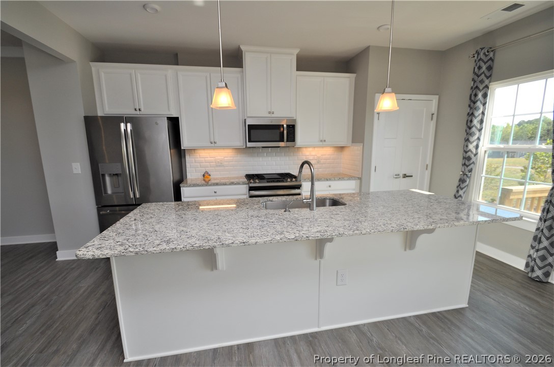200 Misty Pike Drive Raleigh, NC 27603 - Photo 14 of 49 a kitchen with stainless steel appliances granite countertop a sink stove refrigerator and microwave
