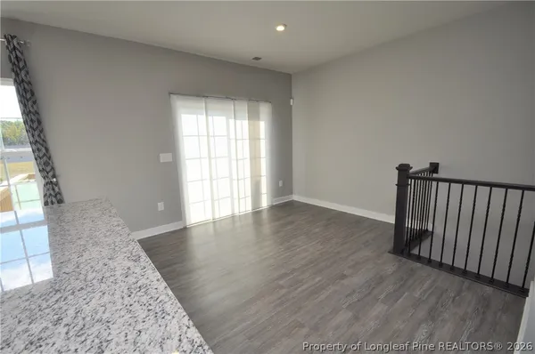 an empty room with windows and ceiling fan