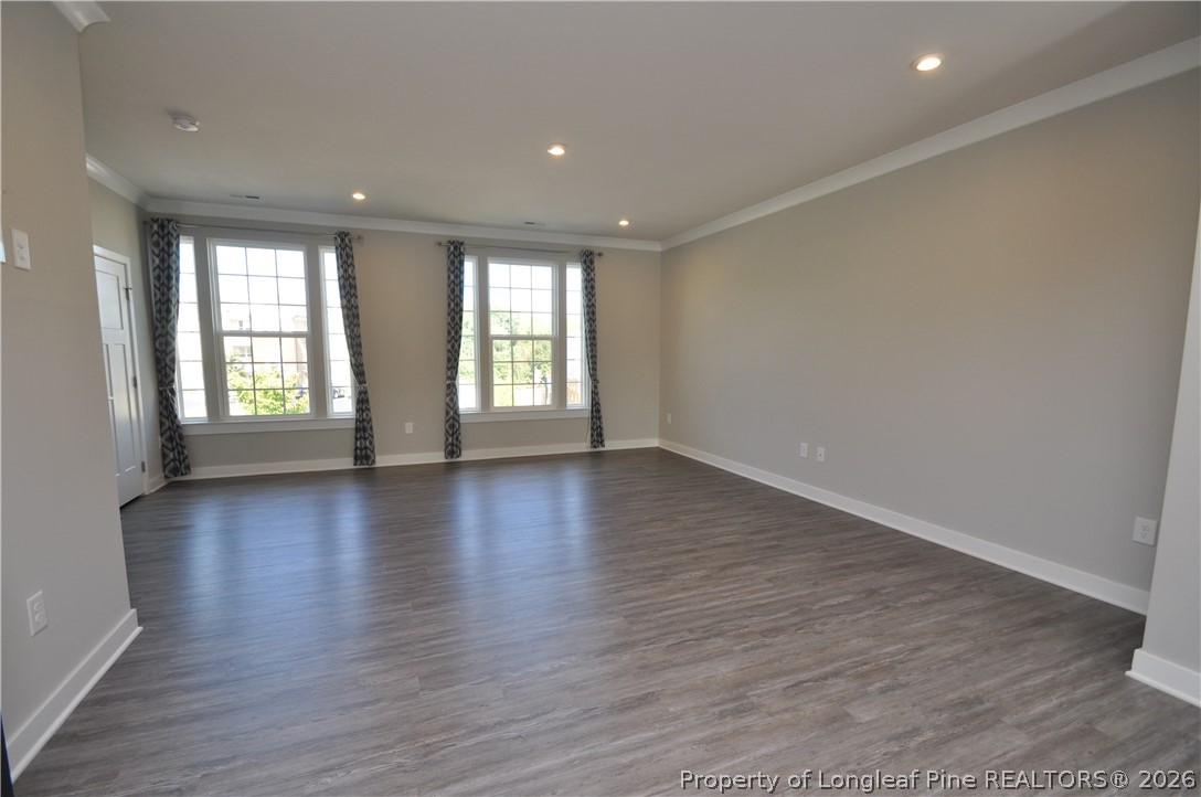 200 Misty Pike Drive Raleigh, NC 27603 - Photo 19 of 49 an empty room with wooden floor and windows with curtains