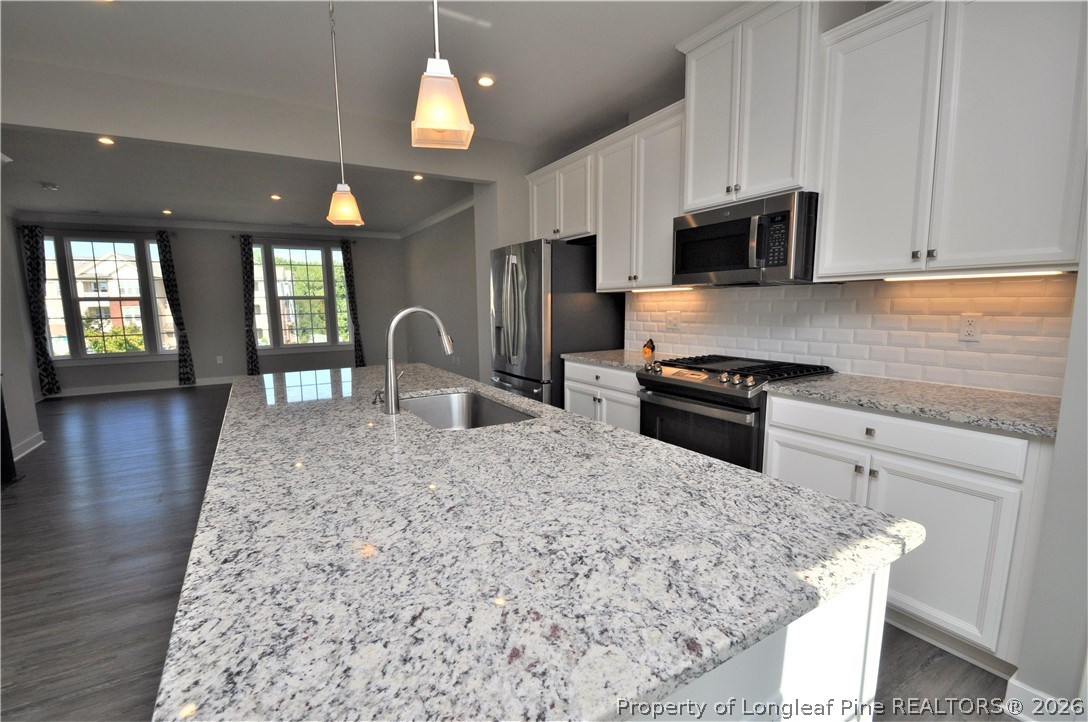 200 Misty Pike Drive Raleigh, NC 27603 - Photo 5 of 49 a kitchen with stainless steel appliances kitchen island granite countertop a stove a sink and a microwave