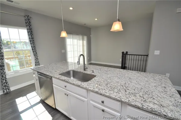 a kitchen with stainless steel appliances granite countertop a sink stove refrigerator and microwave