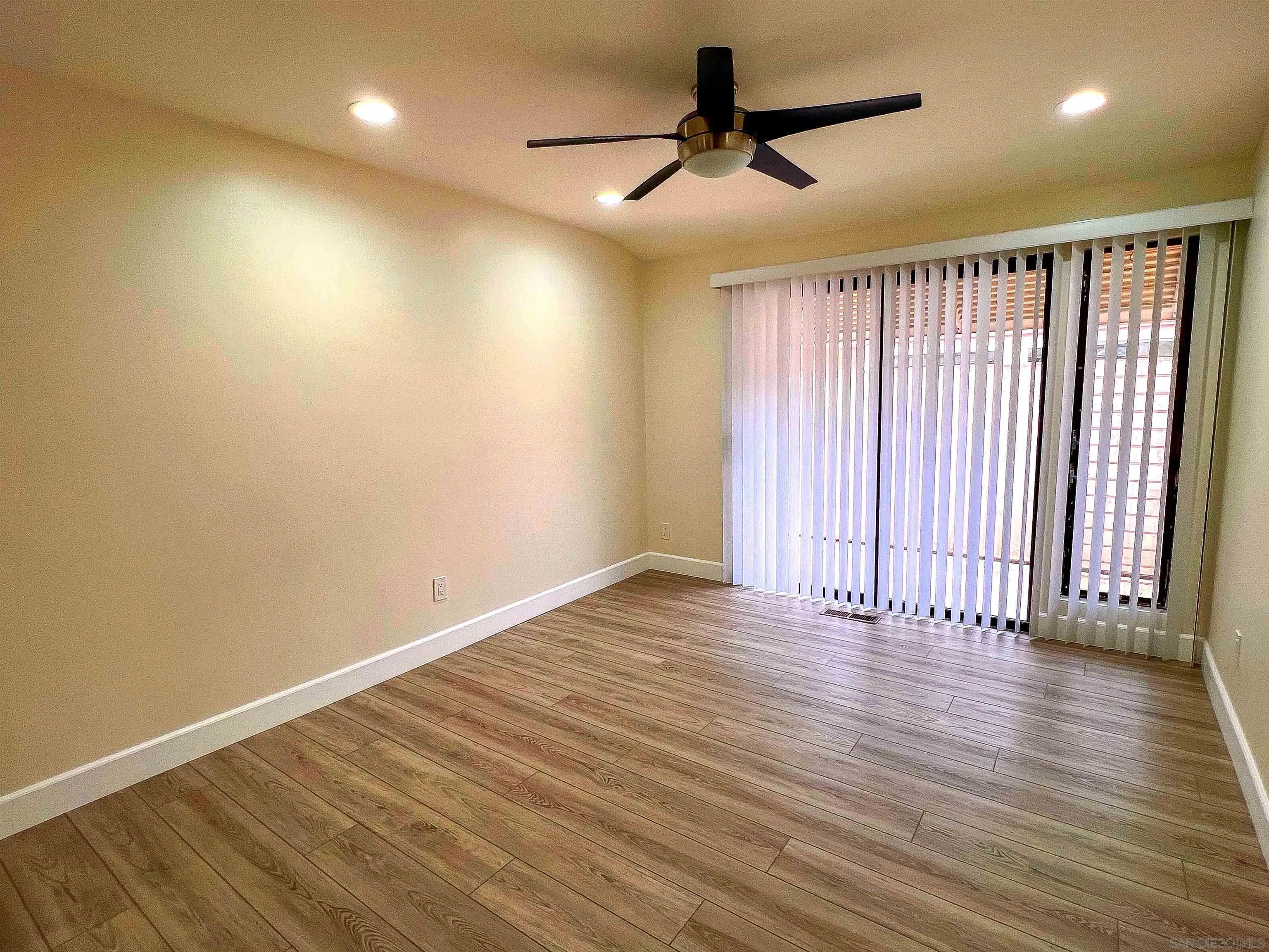 1671 Paseo Bonita La Jolla, CA 92037 - Photo 15 of 17 a view of an empty room with wooden floor and a ceiling fan