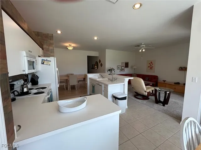 a kitchen with a sink a stove and chairs