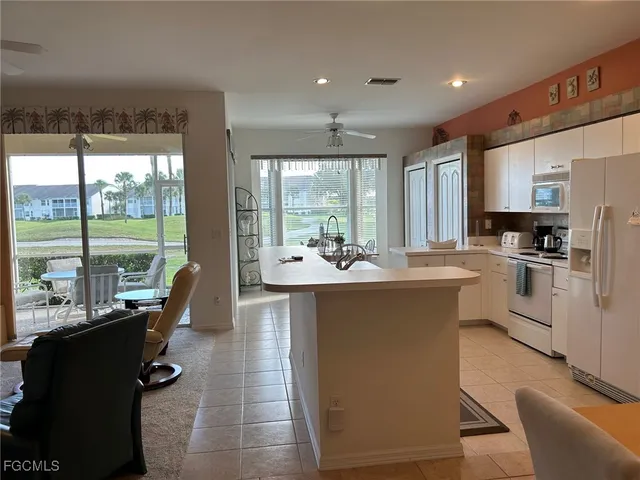 a large kitchen with kitchen island a large window in it