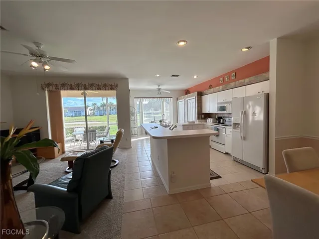 a living room with furniture a large window and kitchen view