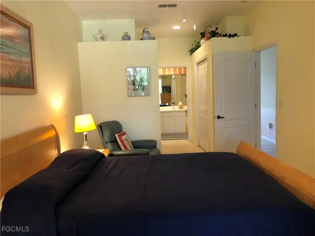 a bedroom with a bed and a lamp with wooden floor