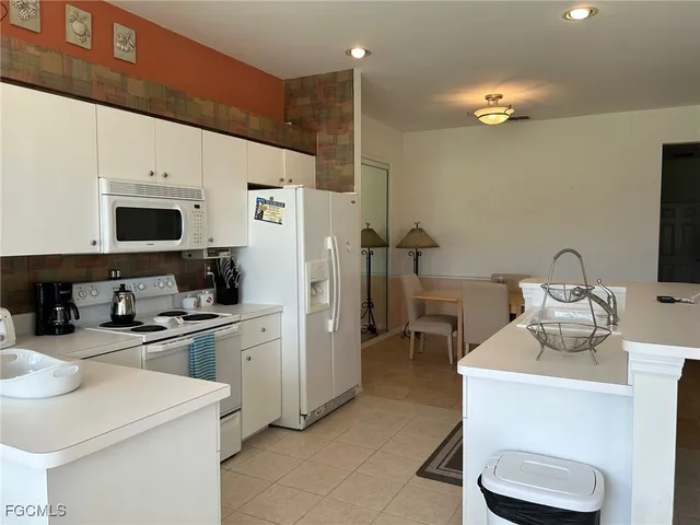 a kitchen that has a sink a stove and chairs