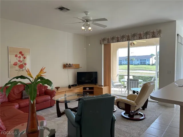 a living room with furniture potted plant and a large window