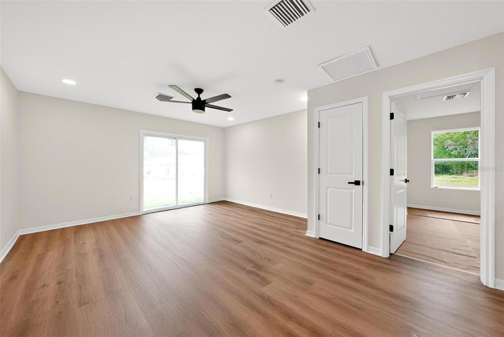 607 Thomas Avenue Leesburg, FL 34748 - Photo 14 of 50 a view of an empty room with wooden floor and a ceiling fan