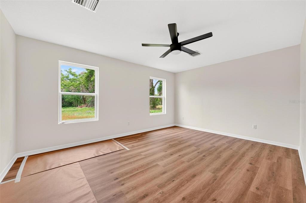 607 Thomas Avenue Leesburg, FL 34748 - Photo 23 of 50 a view of empty room with wooden floor and fan