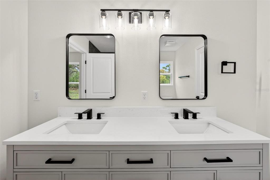 607 Thomas Avenue Leesburg, FL 34748 - Photo 27 of 50 a bathroom with double vanity sinks and a mirror