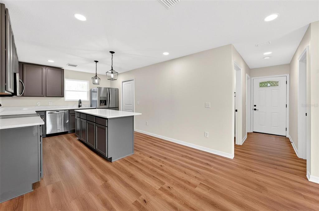 607 Thomas Avenue Leesburg, FL 34748 - Photo 3 of 50 a large kitchen with a center island wooden floor stainless steel appliances and a window