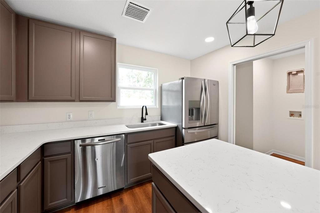 607 Thomas Avenue Leesburg, FL 34748 - Photo 5 of 50 a kitchen with a sink a refrigerator and cabinets