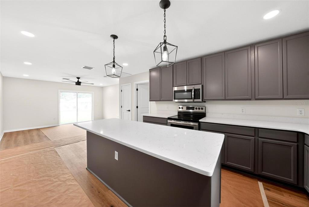 607 Thomas Avenue Leesburg, FL 34748 - Photo 7 of 50 a kitchen with kitchen island a sink appliances and cabinets