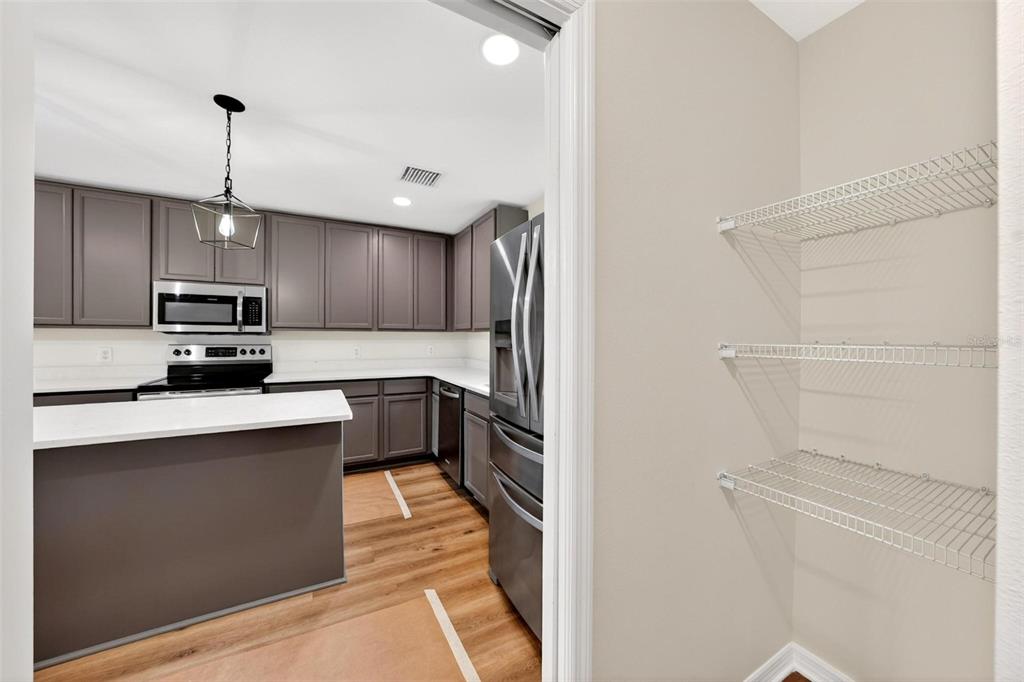607 Thomas Avenue Leesburg, FL 34748 - Photo 9 of 50 a kitchen with kitchen island a counter top space stainless steel appliances and cabinets