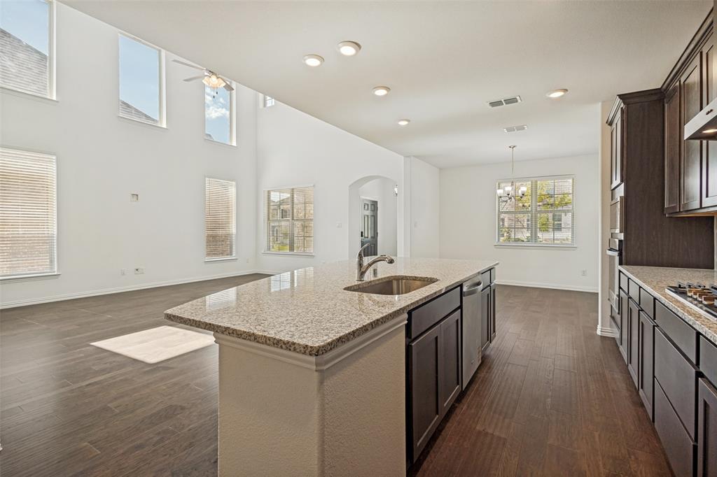 1448 Sun Gdn Way Justin, TX 76247 - Photo 7 of 15 Kitchen island featuring a stainless steel sink, integrated dishwasher, and granite countertop