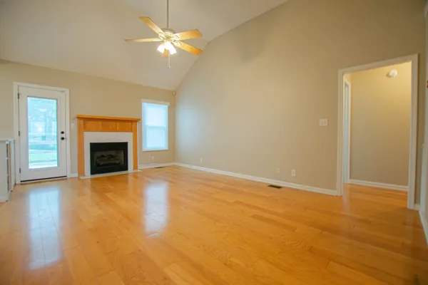 an empty room with windows and fireplace