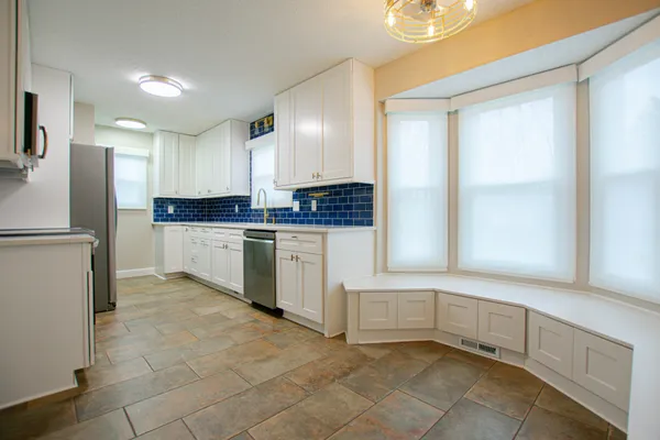 a kitchen with white cabinets and white appliances