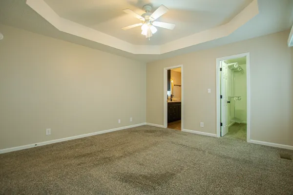 an empty room with closet and a ceiling fan