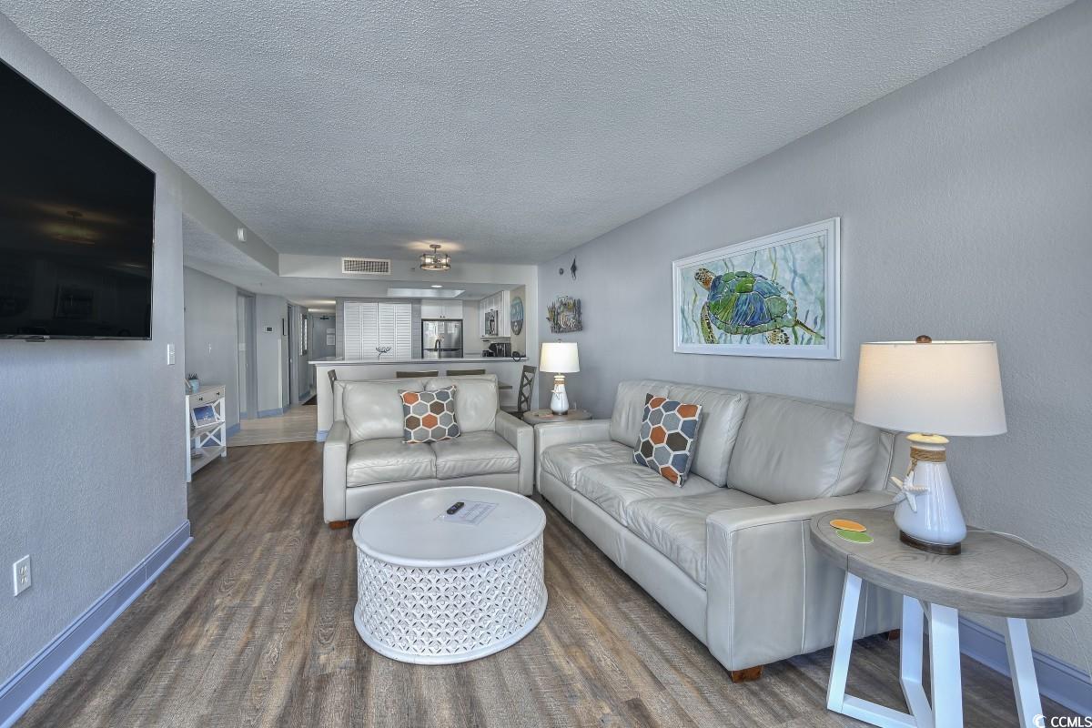 2311 South Ocean Boulevard, Unit 624 Myrtle Beach, SC 29577 - Photo 9 of 28 Living area featuring a textured wall, a textured ceiling, and wood finished floors