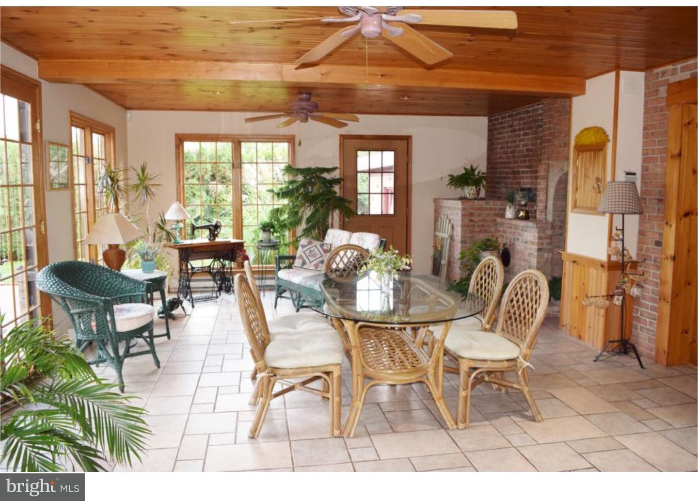 1707 Golf Road Reading, PA 19601 - Photo 11 of 17 a dining room with furniture a floor to ceiling window and potted plants