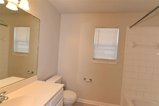 a bathroom with a toilet a sink a vanity and mirror