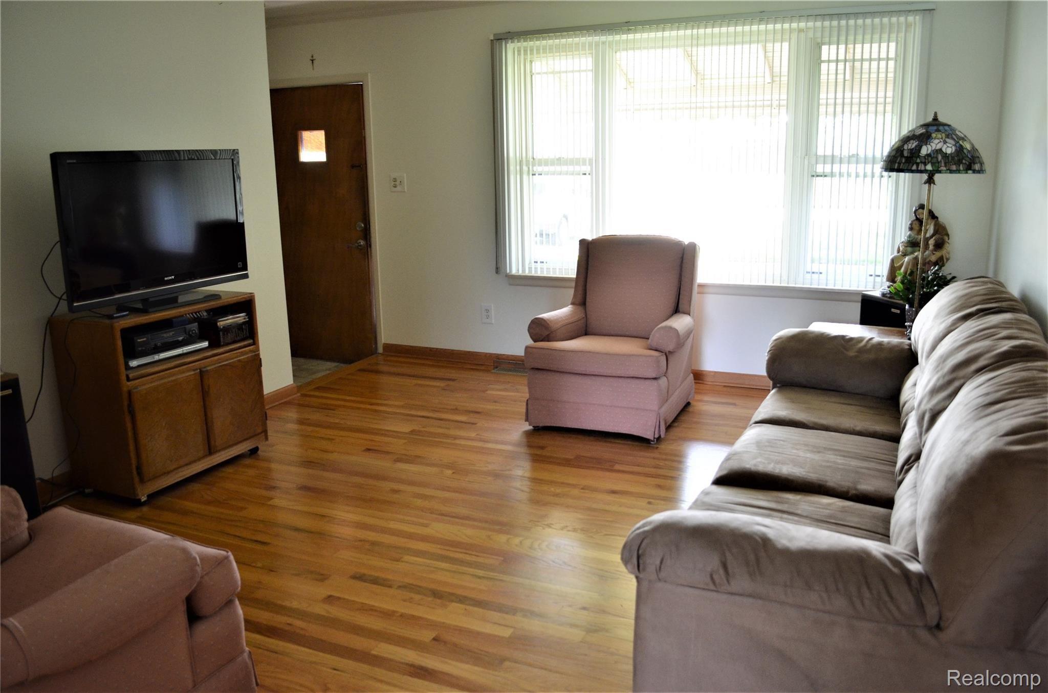 Spacious living room with refinished hardwood floor