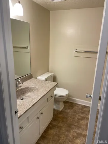 a bathroom with a granite countertop toilet and a sink