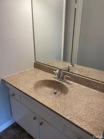 a bathroom with a granite countertop sink and a mirror