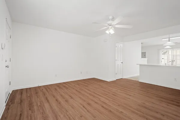 a view of a kitchen with wooden floor and a ceiling fan