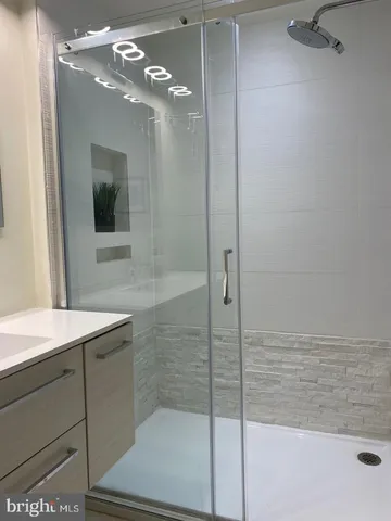 a bathroom with a shower sink and mirror