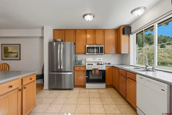 an open kitchen with granite countertop a sink and white cabinets