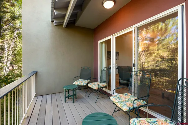 a view of a balcony with wooden floor and outdoor seating