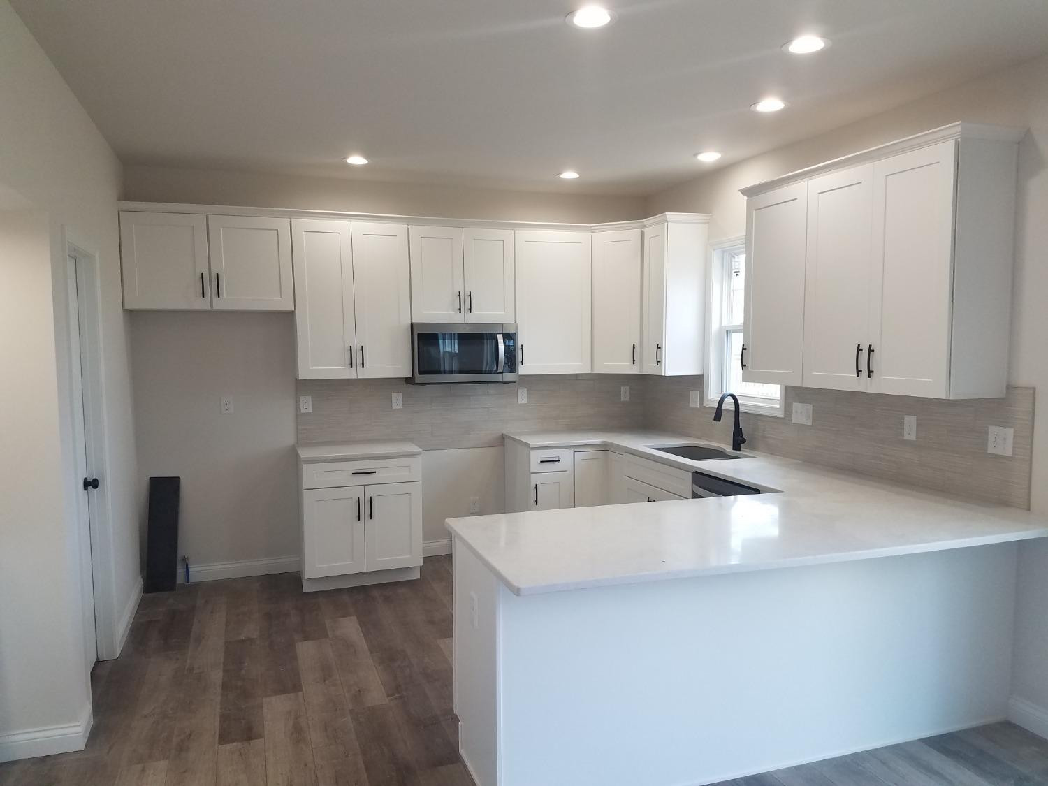 17524 Sunrise Drive Lowell, IN 46356 - Photo 2 of 4 a kitchen with a sink cabinets and wooden floor