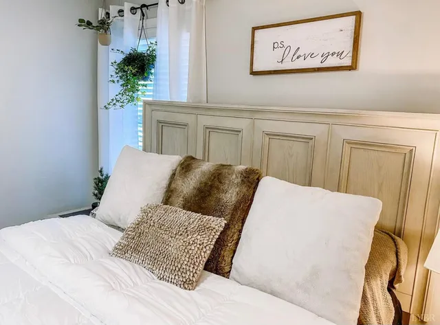 a bedroom with a large bed and a potted plant