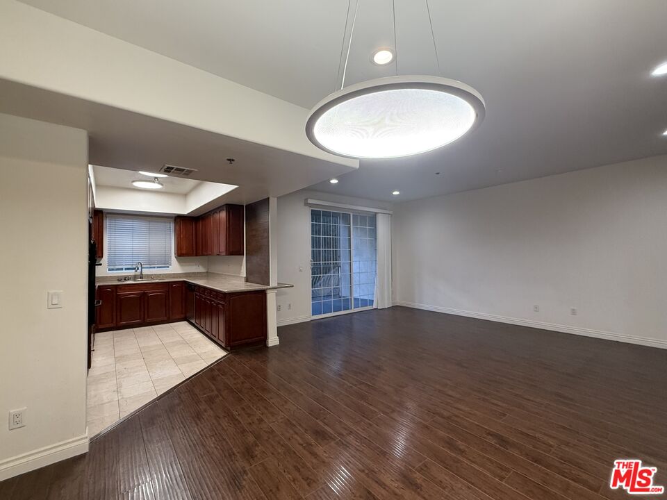 962 Gramercy Drive, Unit 102 Los Angeles, CA 90019 - Photo 16 of 20 an empty room with wooden floor and windows